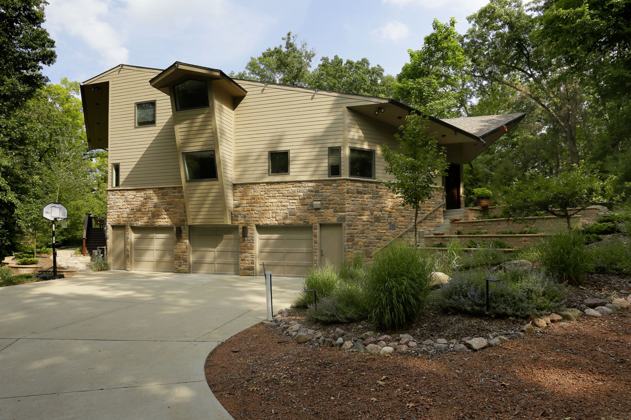 Custom residential home designed by GMF Architecture & Development surrounded by wooded landscaping.